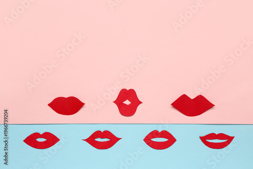 Red paper lips on color bac...
