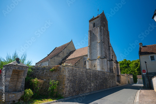 Stone church with tall bell tower in Normandy village