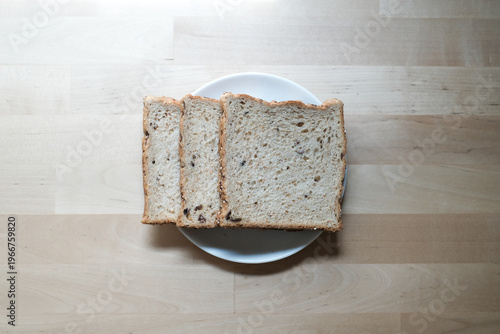 Sliced whole wheat bread on the white plate.top view.