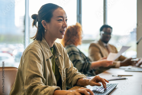 Fotografía Asian businesswoman working on computer with diverse team