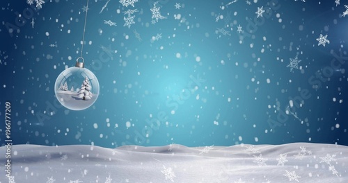Hanging glass bauble showing mini pine trees over snowy field, with falling snowflakes, copy space