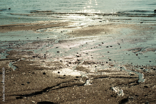 Shimmering sun reflection on sea water and mudflat texture at Silmi beach Incheon South Korea