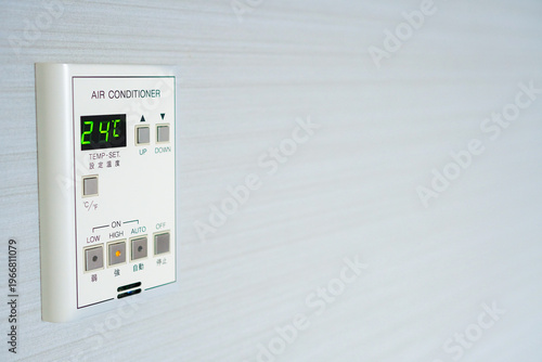 夏の節電と温度調節。壁に設置されたエアコンのリモコンパネルのクローズアップ