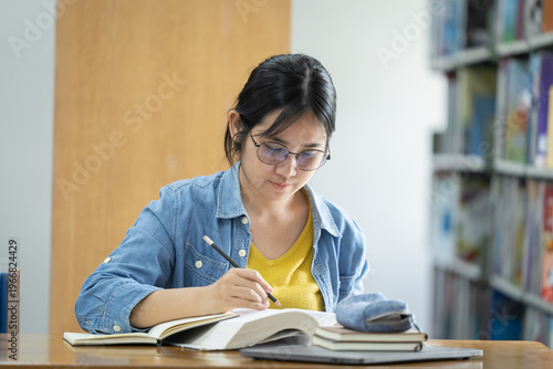 Obraz na płótnie Student studying in library academic environment focused learning peaceful atmos