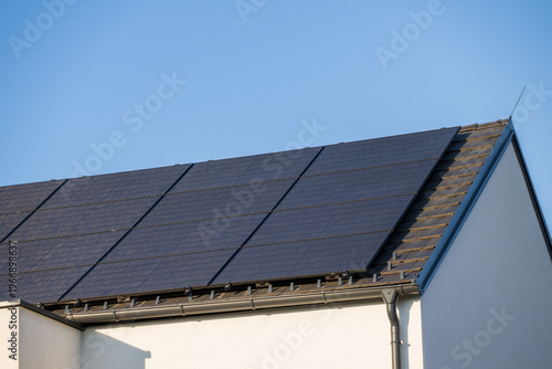 Modern photovoltaic system in black on the roof of a family house