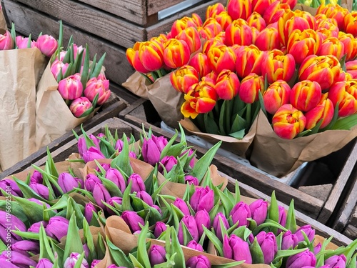 Bouquets of tulips wrapped in paper, arranged in rustic wooden boxes