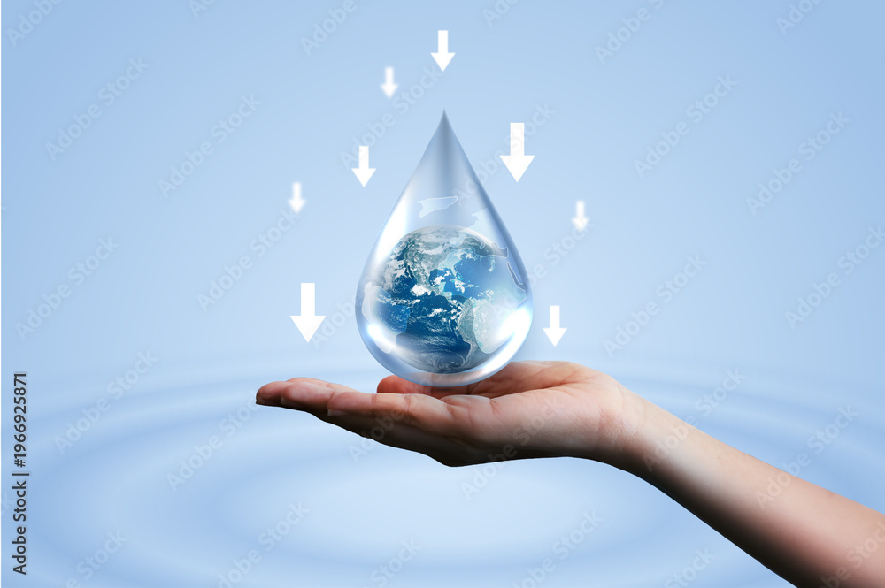 Fototapeta premium Hand holding water drop with Earth inside and downward arrows on blue ripple background. Concept of reducing water consumption, saving global resources, environmental conservation, and sustainability.