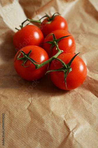 High angle view of juicy tomatoes on a stem, featuring empty space for text, ideal for food blogging, recipe design and healthy lifestyle.