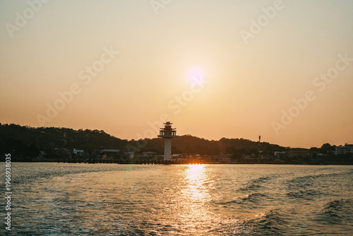 Ship stern cutting through cold waves at golden sunset at Koh Si Chang, Chonburi Province. Dynamic seascape, travel adventure and maritime lifestyle concept.