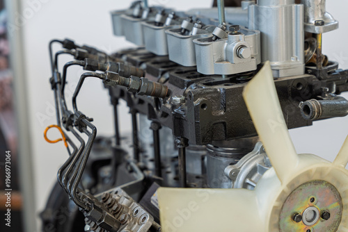 Detailed view of a disassembled diesel engine on display at a trade show, showing the fuel injection lines, rocker arms, and cooling fan, providing a technical look at internal combustion components.
