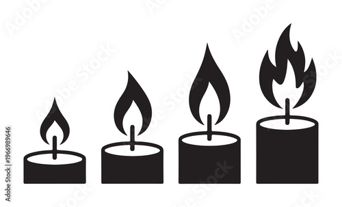 Collection of tea light candles in black holders with burning flames for spa relaxation and interior lighting.