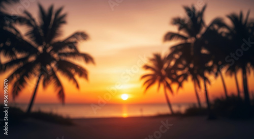Blurred tropical beach sunset with palm tree silhouettes, golden hour sky over the ocean horizon, ideal for summer vacation and travel background concepts