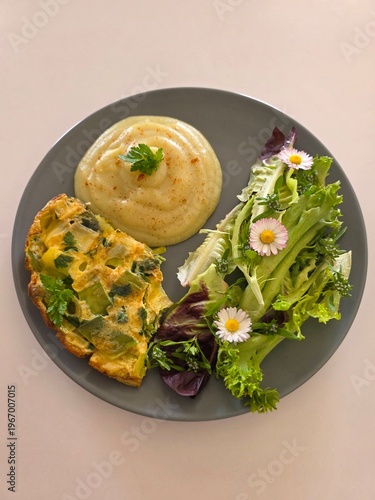 Leek and parsley omelet served with mashed potatoes and spring salad with edible daisies