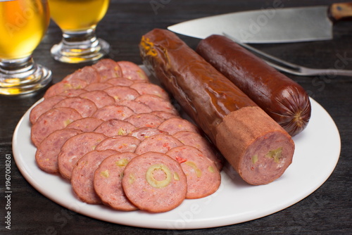 Sliced Salami in a white plate in black background