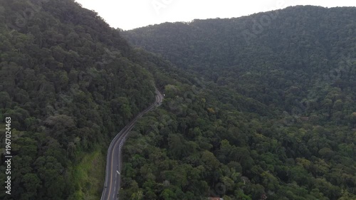 Aerial 4K view of Rio-Santos highway winding through dense tropical rainforest mountains