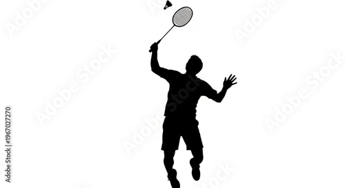 Silhouette of a man playing badminton hitting shuttlecock.