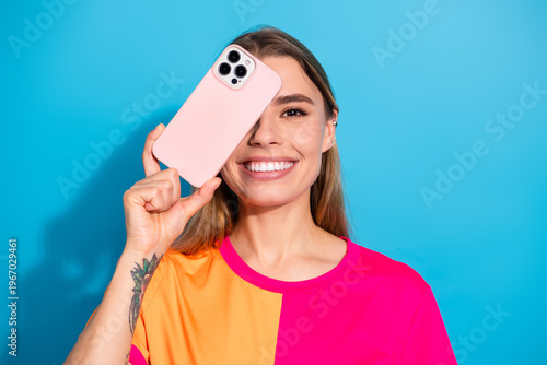 Bild auf Leinwand Young woman with pink phone against blue background smiling in bright casual fas