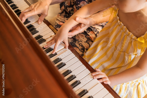 Grandmother and granddaughter playing piano together learning music at home education and bonding