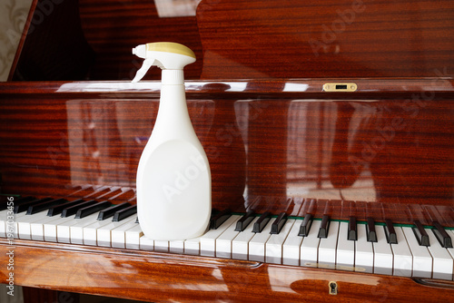 Piano keys cleaning with spray bottle and cloth delicate maintenance dust removal and hygiene care