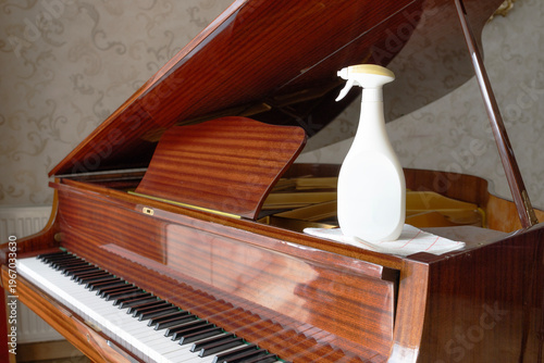 Piano keyboard cleaning concept spray bottle cloth hygiene maintenance and dust removal at home