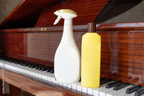 Delicate cleaning of piano keyboard with spray bottle and cloth dust removal and hygiene concept