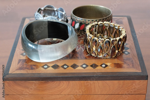 Billede på lærred Collection of chunky bracelets on inlaid wooden jewelry box.