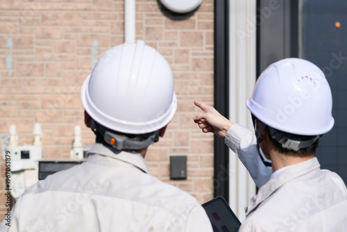 Bild auf Leinwand 作業服を着て住宅の点検をする日本人男性