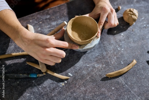 Tablou pe pânză Creative moments in a pottery studio with a talented young woman shaping clay