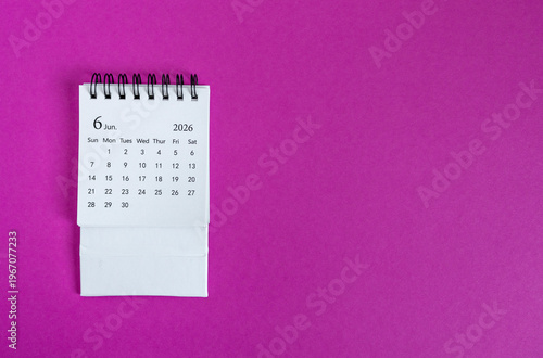 Desk calendar for June 2026 on a bright pink background.