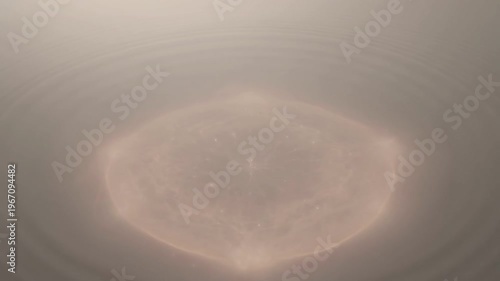 The glowing object radiates light underwater creating ripples.