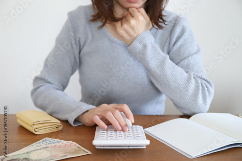 電卓を使い家計に悩む女性