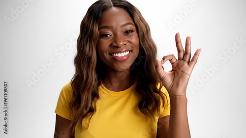 Young Black Woman Sitting Cross-Legged Smiling and Giving an Ok Sign