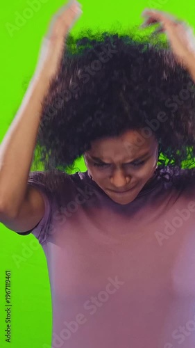 Frustrated young African American woman with curly hair showing stress and anxiety in multiple facial expressions on green background. Emotion, female, mental health, isolated portrait.
