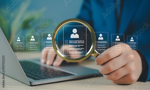 person using magnifying glass to search for candidates on laptop