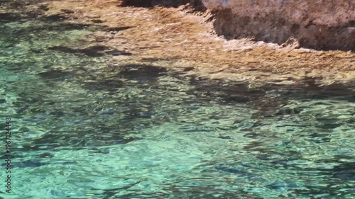 Crystal clear turquoise water lapping on rocky coast