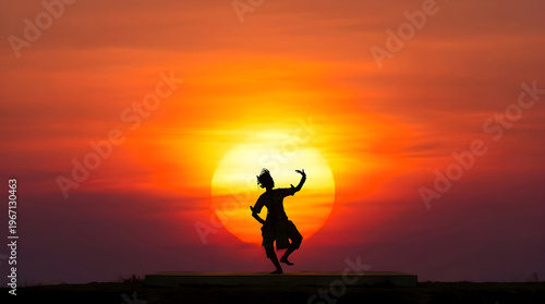 Silhouette of Thai Khon Dancer Performing at Sunset with Big Sun
