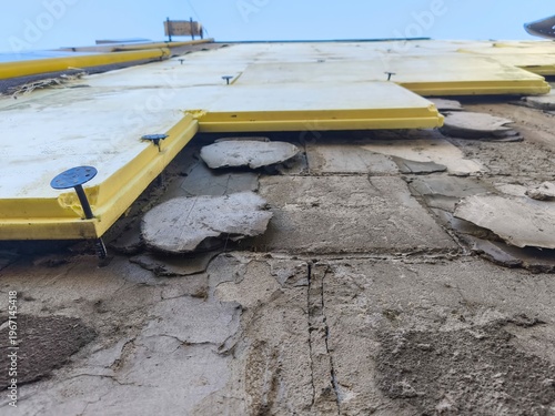 Building facade renovation with yellow insulation boards installed on damaged exterior wall showing construction repair progress