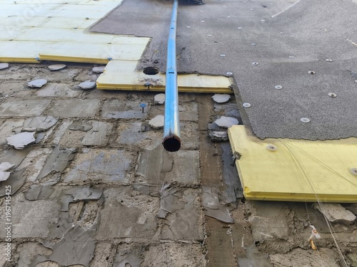 Building exterior with insulation panels removed revealing damaged concrete surface and renovation work in urban setting