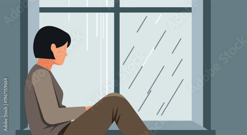 A person with dark hair sits quietly by a window while it rains outside indoors