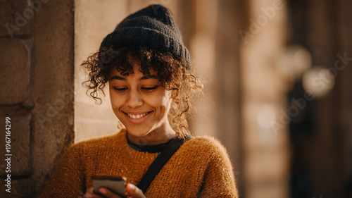 Young adult looking at phone with heartfelt smile