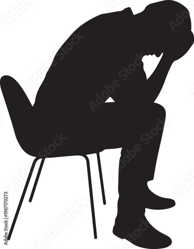 Silhouette of man sitting on chair with head in hands, sad and stressed.