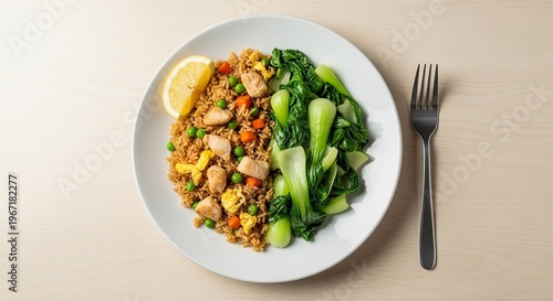 A vibrant plate of fried rice features tender chicken fresh bok choy peas and a bright lemon wedge garnish