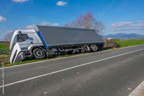 Foto A truck is bent on its side after going off the road