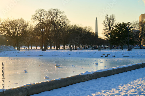 Capitol Reflecting Pool frozen in winter with Washington Monument obelisk at the background