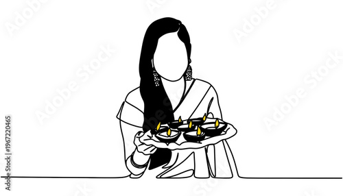 A woman in traditional Indian attire holding a tray of diyas