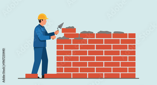 A construction worker in a yellow hard hat builds a brick wall with a trowel