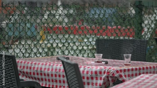 Rain Falling on Tea Glasses at Seaside Cafe Table Cinematic Mood Shot
