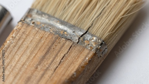 Close-up View of Worn Paintbrush with Visible Wear and Tear on Wooden Handle and Bristles