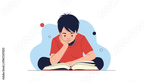 Young boy in a red shirt sits cross-legged on the floor and focuses intently on reading an open book in a quiet and studious setting.