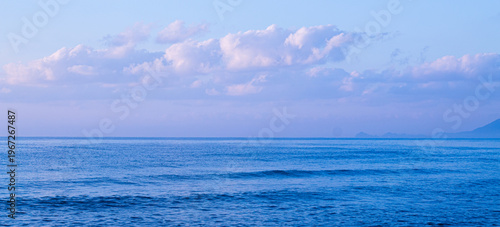 Photos Soft pastel beach shoreline with gentle waves washing sandy coast under calm eve
